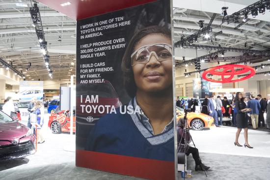 
	丰田制作的印有美国工人图像和标语的巨幅海报：我是美国丰田 
