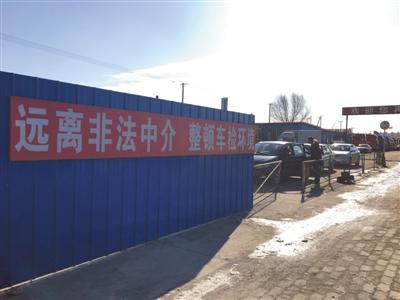 “远离非法中介 整顿车检环境”的大标语下,一些“黄牛”涉嫌代人验车违规通关。摄影/新京报记者 陈奕凯 游天燚