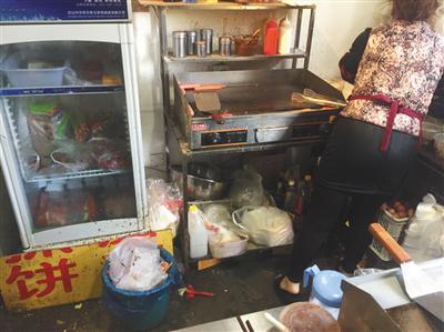 同时入驻了三家外卖平台的“台湾手抓饼”店内，老板娘正在加工食物，店内卫生条件差。后该店被查出无证经营。新京报记者 张越摄