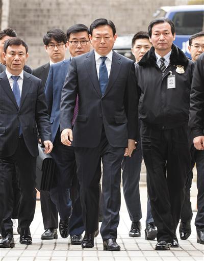 3月20日,乐天集团会长辛东彬(中)到达韩国首尔中央地方法院,准备出席庭审。新华社发
