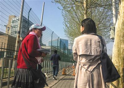 一位“存包人”(左)正在询问是否需要存包。