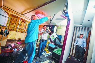 昨天上午，在朝阳区九龙花园，工人对一处群租房内的隔断进行拆除。 本报记者 邓伟摄