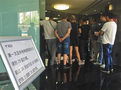 2017年6月1日，海淀区中国技术交易大厦易到公司，在一层电梯旁放着指示牌，几位司机站在一楼电梯口讨论欠款未到账，前来讨要欠款。新京报记者 王飞摄