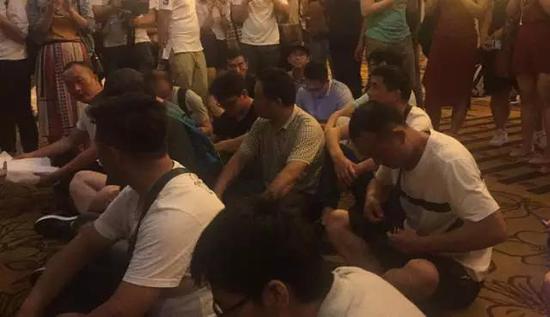 警察调解后,债权人在会场门口静坐 本报记者 蒋洁琼摄