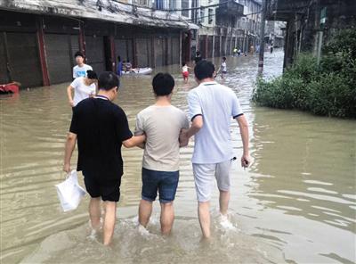 2016年9月，浙江苍南县雨季，警方趟着城中积水将犯罪嫌疑人杨琛送进看守所。警方供图 