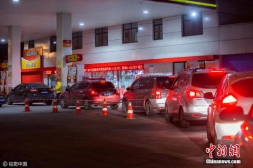资料图：车主在加油站排队加油。图片来源：视觉中国