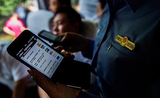 工商执法人员查到传销人员手机里编发的“传销微信”。视觉中国 资料 