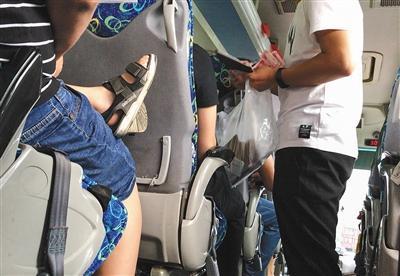 8月19日，在前往长城的旅游大巴上，导游向游客收钱购买滑车往返票。