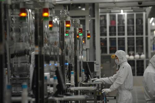 资料图片:2011年6月10日，工作人员在日本茨城县瑞萨电子公司工厂内工作。新华社发