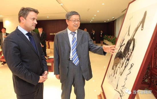 图为唐双宁向到访中国光大集团的卢森堡首相贝泰尔赠送绘画作品