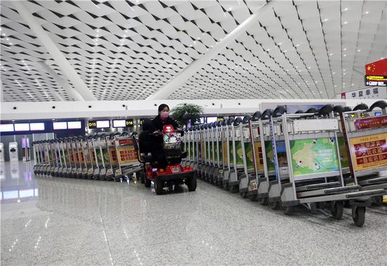 机场工作人员整理散落在各处的小推车，以备明天的乘客使用。