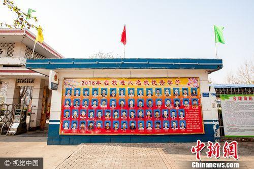 2017年4月3日，河北省保定市“雄安新区”雄县中学门口两侧的墙上，展示着该校2016年高考优秀学子的大幅照片。图/CFP