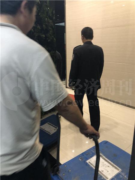警察在前面引路,搬运人员在后面跟着,到达2楼,是善林金融行政部门的楼层(《中国经济周刊》记者 宋杰 摄)