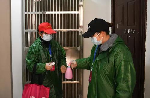 湖北省武汉市青山区青和居社区党总支书记、居委会主任桂小妹(右)和网格员李文丽进楼道准备开展逐户排查(2月18日摄)。新华社记者 程敏 摄