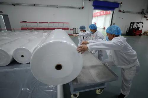 在中国石油辽阳石化公司聚酯厂车间,工人运送刚生产完的熔喷无纺布(4月20日摄)。新华社记者 杨青 摄