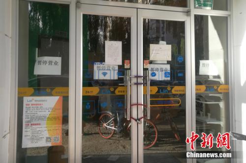 北京街边的某邻家便利店大门紧锁,并张贴着暂停营业的公告。谢艺观 摄