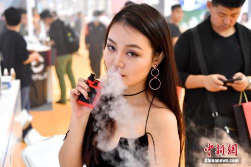 资料图:美女手持电子烟体验。 中新社记者 陈文 摄