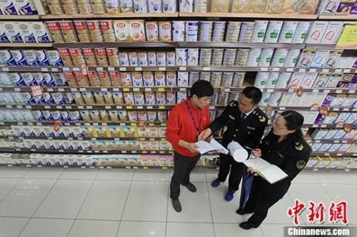 资料图:超市内工作人员在检查奶粉。中新社记者 张娅子 摄