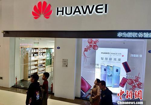 资料图:民众从华为手机专卖店前经过。中新社记者 吕明 摄