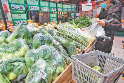 朝阳区一超市果蔬区，蔬菜包裹在塑料袋内，成袋销售。顾客正在使用塑料连卷袋选购蔬菜。本报记者 潘之望摄