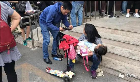 抱着孩子来办理落户手续的人们     《等深线》记者 张晓迪 摄影