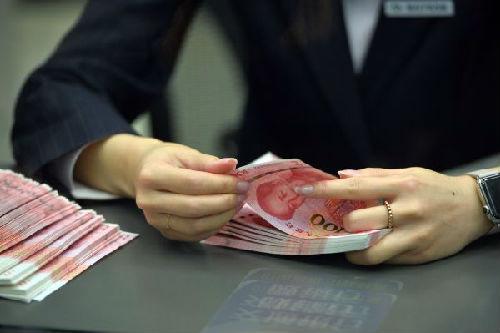 资料图：交通银行北京市分行营业部的柜台工作人员在清点新版百元钞票。 新华社