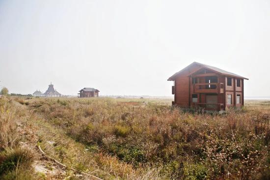 一片曾经喧闹的海边沙滩游乐场正在被野草“吞噬”。