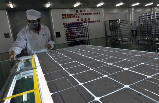 资料图：2011年3月14日，在广西桂林市兴安县太阳能光伏产业园，桂林尚科光伏应用有限公司的职工在检测产品。
