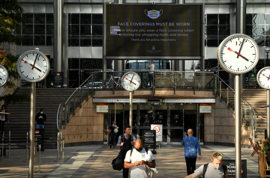 英国伦敦,冠状病毒病爆发期间,人们走在金丝雀码头商业区。