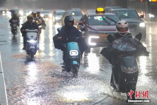 7月31日，北京强降雨持续，市民在雨中骑车出行。 中新社记者 贾天勇 摄