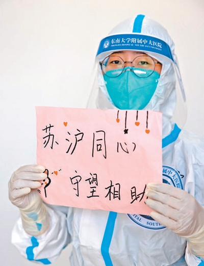 4月6日,在上海临港方舱医院,一名来自江苏的医生展示“苏沪同心 守望相助”表达愿望。 新华社记者 金立旺摄