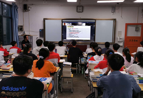 (新东方老师通过双师直播课堂为普安一中师生远程授课)