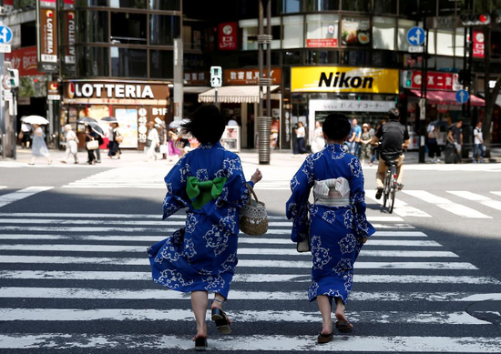 资料图片:2018年7月,日本东京,两名身着和服的女子经过购物街区的人行横道。REUTERS/Kim Kyung-Hoon