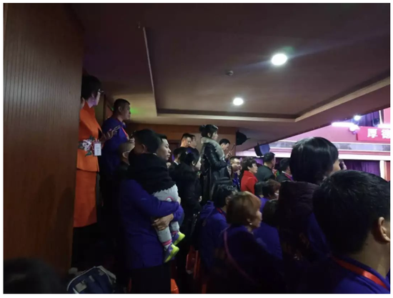 ↑2000人的会场爆满,大量参会人员在后排添加塑料椅子就坐。图为抱孩子的参会人员站立参会。图片来源:每日经济新闻