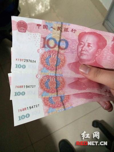 邓先生手中的三张百元假钞中，有两张的编号完全一样。（图片来源：红网）