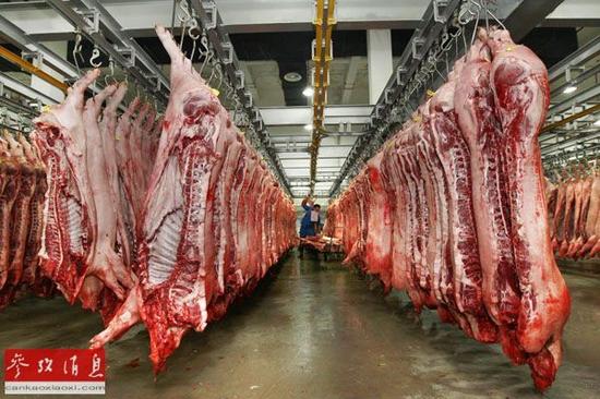 资料图片:在上海农产品中心批发市场内,商贩在整理猪肉.