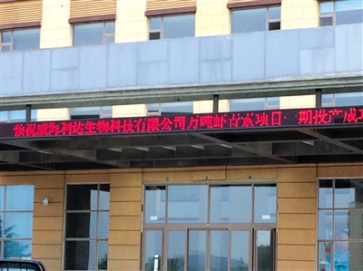 威海利达生物科技有限公司行政楼，电子器上写着“预祝威海利达生物科技有限公司年产万吨虾青素项目一期投产成功”。