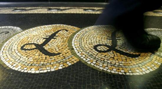 2008年3月25日，英国央行一名雇员经过总部大厅内以马赛克铺成的英镑货币符号图案。
REUTERS/LUKE MACGREGOR