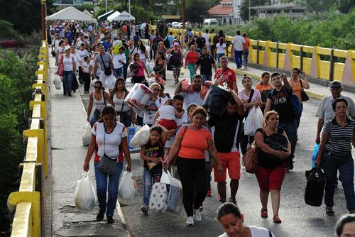 7月10日，在委内瑞拉和哥伦比亚边境，委内瑞拉人携带从哥伦比亚库库塔采购的食品杂货通过西蒙·玻利瓦尔桥返回塔奇拉。新华社/法新
