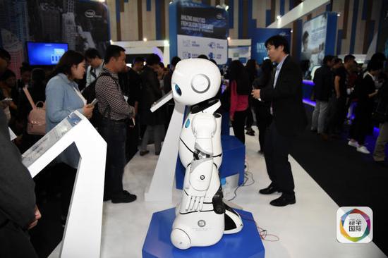 5月26日，观众在博览会现场参观智能机器人。