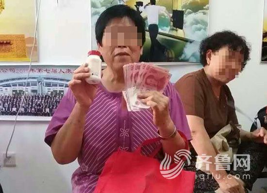 老人拿着买保健品的钱和买的保健品合影