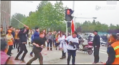 黑衣男子持棍殴打白衣男子(视频截图)