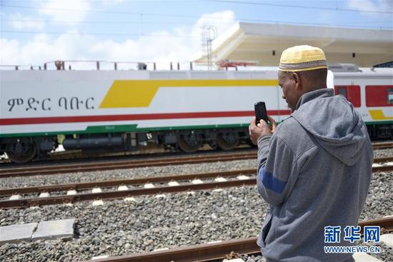 10月1日，在埃塞俄比亚首都亚的斯亚贝巴，一名当地人在拉布车站拍摄即将通车的亚吉铁路上的火车。