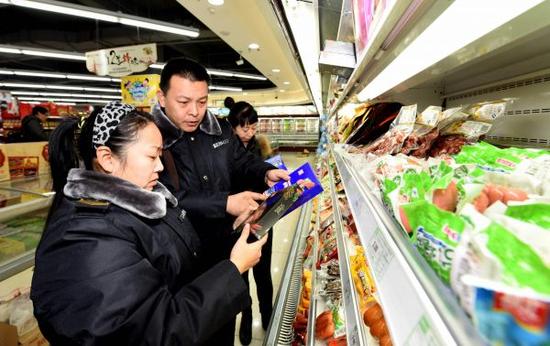 资料图：食品药品监督管理局执法人员在辖区一家超市检查。新华社记者王晓摄