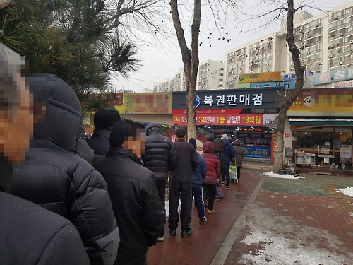 资料图片：2016年1月21日，在首尔一彩票销售店，80多名市民为购买彩票排起长龙。（韩联社）