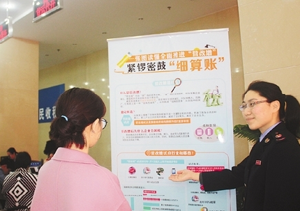 浙江某县国税局工作人员帮纳税人计算“营改增”详细账目。    资料图