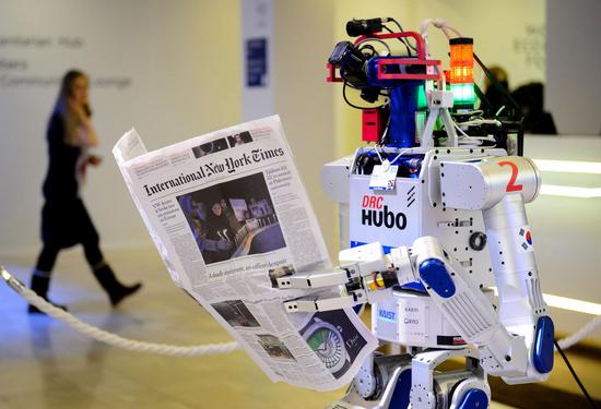 去年达沃斯论坛年会场内带着嘉宾名牌载歌载舞，与嘉宾互动交流还看报纸的Hubo机器人