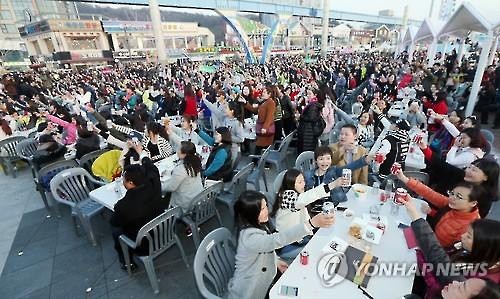 资料图片：2016年3月28日下午，在仁川市月尾岛文化街，几千人举杯共饮。（韩联社）