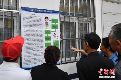 资料图:民众阅读办理居住证的相关要求细则。 中新社记者 崔楠 摄