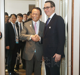 3月17日，日本财务相麻生太郎（左）在德国巴登-巴登与美国财政部长努钦首次会谈。图片由财务省提供。（共同社）